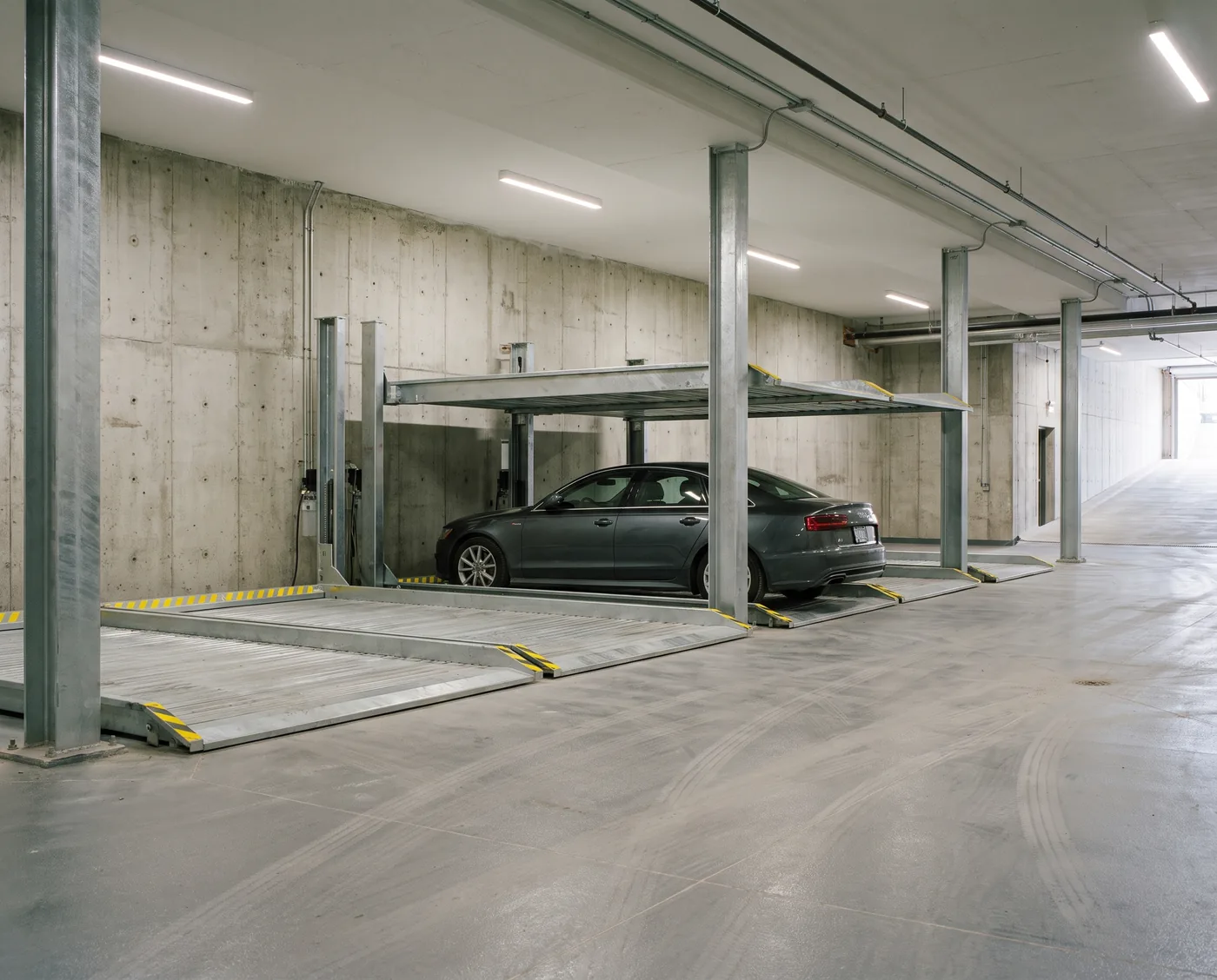 Semi-automated parking platforms installed in the concrete parking level of a residential development
